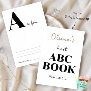 May include: Two white baby books with black and gray text. One book reads "A is for..." and the other reads "Olivia's First ABC BOOK". The books have lines for writing and the text "Made with love" is printed on the bottom.