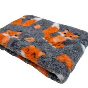 May include: A grey and orange plush blanket with a fox print. The blanket is soft and fluffy and would be perfect for a pet bed.