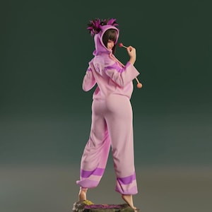 May include: A pink and purple figure of a woman wearing a hooded jumpsuit with a lollipop in her hand. The figure is standing on a rock base.