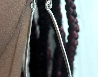 Puede incluir: Pendientes de plata en forma de lágrima con textura martillada.