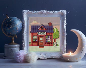 May include: A white frame with a pixelated image of a red brick building with a sign that says "BOOKS". The building has a purple roof and a small tree in front of it. The image is set against a blue sky with stars.