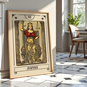 K&ouml;nnte beinhalten: Ein gerahmter Kunstdruck der Tarotkarte Gerechtigkeit, beschriftet mit XI und JUSTICE. Die Abbildung zeigt eine gekr&ouml;nte Figur auf einem Thron zwischen zwei S&auml;ulen, die ein vertikales Schwert in der einen und eine Waage in der anderen Hand h&auml;lt.