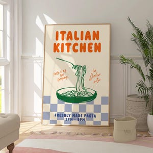 May include: A poster with the text "ITALIAN KITCHEN" in orange and green lettering. The poster features a green illustration of a pan of pasta with the text "Pasta is my love language" and "La Dolce Vita" in the background. The poster also includes the text "FRESHLY MADE PASTA 3PM - 9PM".