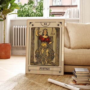 K&ouml;nnte beinhalten: Ein rechteckiger gerahmter Druck, der die Tarotkarte Gerechtigkeit zeigt, oben mit XI und unten mit JUSTICE beschriftet. Die Abbildung zeigt eine gekr&ouml;nte Figur, die auf einem Thron zwischen zwei S&auml;ulen sitzt und ein Schwert sowie eine Waage h&auml;lt.