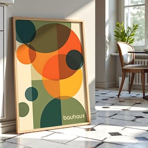Pu&ograve; includere: Una stampa incorniciata con un design geometrico che presenta cerchi sovrapposti in tonalit&agrave; di verde, arancione, giallo e marrone. La stampa ha la parola "bauhaus" nell'angolo in basso a destra.