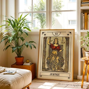 K&ouml;nnte beinhalten: Ein gerahmter Kunstdruck der Tarotkarte Gerechtigkeit, beschriftet mit XI und JUSTICE. Die Illustration zeigt eine gekr&ouml;nte Figur, die zwischen zwei S&auml;ulen sitzt und ein Schwert sowie eine Waage h&auml;lt, dargestellt in Schwarz, Gold und Rot.