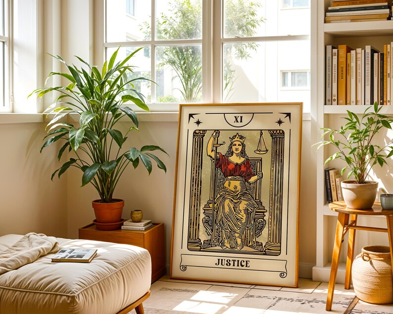 K&ouml;nnte beinhalten: Ein gerahmter Kunstdruck der Tarotkarte Gerechtigkeit, beschriftet mit XI und JUSTICE. Die Illustration zeigt eine gekr&ouml;nte Figur, die zwischen zwei S&auml;ulen sitzt und ein Schwert sowie eine Waage h&auml;lt, dargestellt in Schwarz, Gold und Rot.