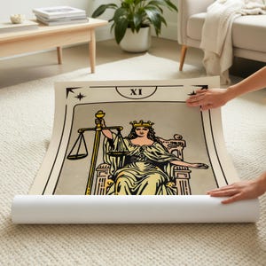 May include: A rolled-up tarot card print featuring the Justice card. The illustration depicts a woman with a crown, holding scales and a sword. The card has a beige background with black and gold accents, and the Roman numeral XI.