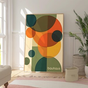 Pu&ograve; includere: Stampa d'arte geometrica astratta con cerchi sovrapposti in tonalit&agrave; di verde, arancione, giallo e marrone. La stampa ha la parola "bauhaus" in basso.