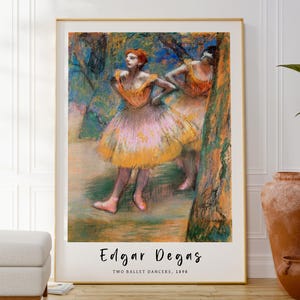 Puede incluir: Una pintura en colores pastel de dos bailarinas en un entorno de bosque. Las bailarinas llevan tutús amarillos y rosas y están en medio de una pose. La pintura se titula "Edgar Degas, Dos bailarinas de ballet, 1898".