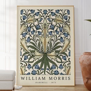 May include: A vintage-style poster featuring a floral pattern with blue and green flowers on a cream background. The poster has the text "William Morris Harebell - 1875" at the bottom.