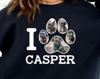 May include: Black sweatshirt with the text "I CASPER" in white. A paw print design in the center features five images of a French Bulldog. The sweatshirt is a dark color and has a crew neck.