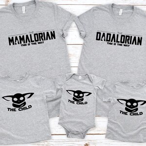 May include: A family set of gray t-shirts and a onesie. Two adult shirts read "The Mamalorian" and "The Dadalorian", with "This is the Way" below. The other shirts and onesie say "The Child" with a black graphic.