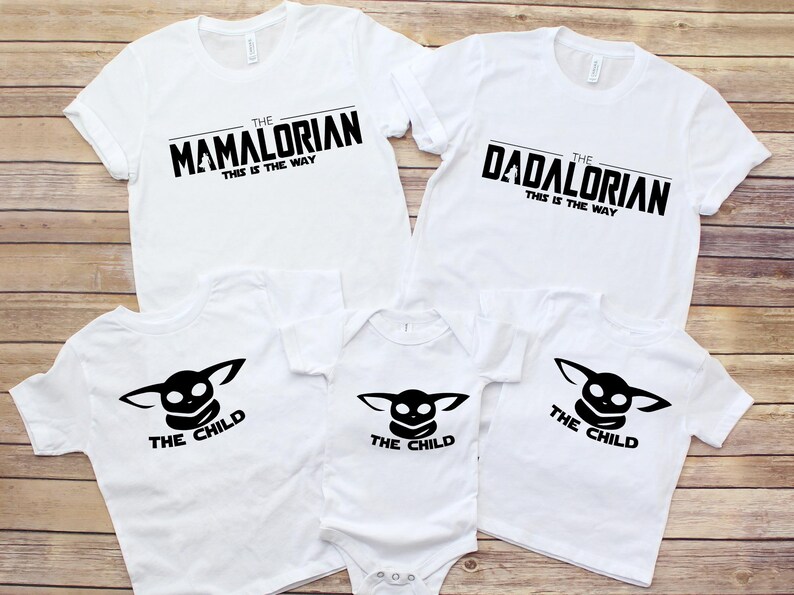May include: White t-shirts with black text. The shirts read "The Mamalorian" and "The Dadalorian" with "This is the Way" underneath. Other shirts and a onesie feature "The Child" graphic.