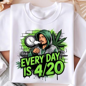 Op de afbeelding: Wit sweatshirt met een groene en zwarte afbeelding van een persoon die rookt en een klok met de tekst "EVERY DAY IS 4/20".
