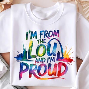 May include: White sweatshirt with the text "I'M FROM THE LOU AND I'M PROUD" in colorful tie-dye lettering. The design includes a skyline and the Gateway Arch, with splashes of rainbow colors.