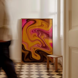 May include: A rectangular framed wall art piece featuring a vibrant abstract design with swirling patterns of deep magenta, bright orange, golden yellow, and dark brown colors. The artwork is encased in a thin, light-toned wooden frame.