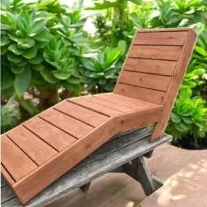 May include: A wooden lounge chair with a slatted design. The chair is made of natural wood and has a rustic look. It is perfect for relaxing outdoors.