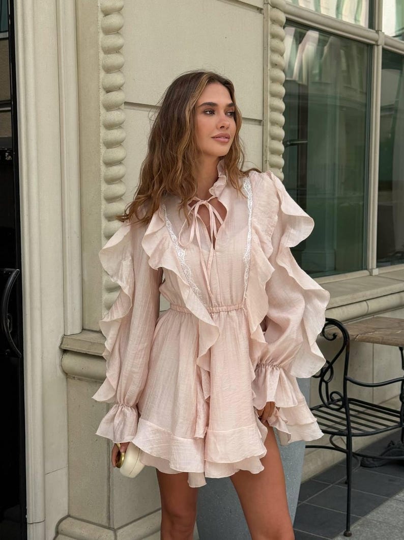 K&ouml;nnte beinhalten: Eine wei&szlig;e Keramik-Tasse mit schwarzem Henkel und dem Text "But First, Coffee" in schwarzer, handschriftlicher Schrift. Die Tasse steht auf einer wei&szlig;en Oberfl&auml;che.