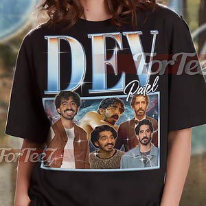 May include: Black unisex t-shirt featuring a graphic of Dev Patel with the name "DEV Patel" in a retro style. The shirt has a crew neck and short sleeves. The model is wearing an XL shirt. The shirt is made of a soft material.