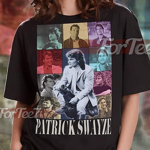May include: Black unisex t-shirt featuring a collage of Patrick Swayze images. The shirt includes the text "PATRICK SWAYZE" in white block letters. The shirt is a classic crew neck style.