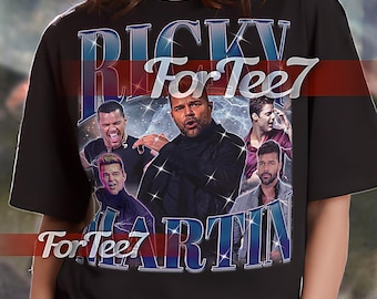 May include: Black unisex t-shirt with a graphic print of Ricky Martin. The graphic features a collage of images of Ricky Martin with the text "For Tee7" in blue and white.