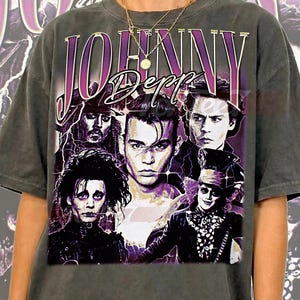 Peut inclure: T-shirt unisexe gris avec un imprimé violet et blanc de Johnny Depp et le nom "JOHNNY Depp". Le design présente des images de Depp dans différents rôles. Le t-shirt a un aspect vintage.