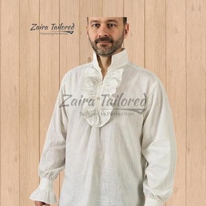 Op de afbeelding: Wit overhemd met lange mouwen met een gerimpelde kraag en manchetten. Het overhemd heeft een hoge kraag en een knoopsluiting aan de voorkant. De merknaam "Zaira Tailored" is op het overhemd gedrukt. Gemaakt van een lichte stof.