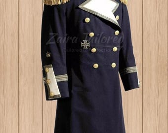 May include: A dark blue double-breasted coat with gold buttons and trim. The coat has a white collar and cuffs with gold accents. The coat is a traditional style with a long length and a high collar.