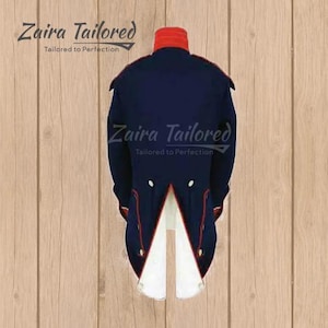 Peut inclure: Une veste queue-de-pie bleu marine de style militaire avec un col montant rouge, des passepoils rouges et une doublure int&eacute;rieure blanche au niveau de la fente arri&egrave;re. Le texte Zaira Tailored Tailored to Perfection est inscrit en lettres cursives.