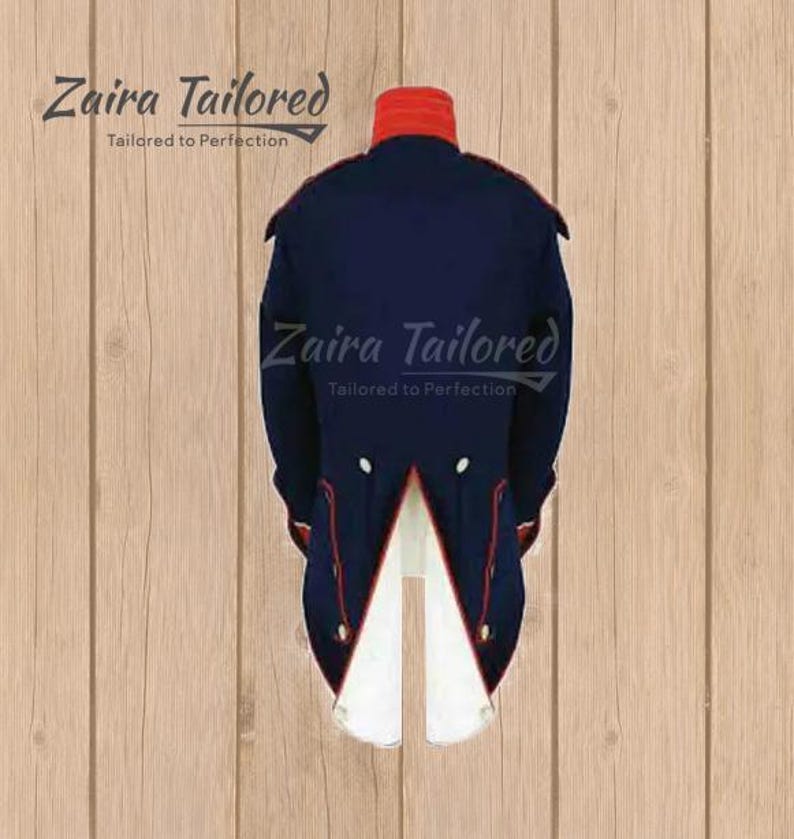 Peut inclure: Une veste queue-de-pie bleu marine de style militaire avec un col montant rouge, des passepoils rouges et une doublure int&eacute;rieure blanche au niveau de la fente arri&egrave;re. Le texte Zaira Tailored Tailored to Perfection est inscrit en lettres cursives.