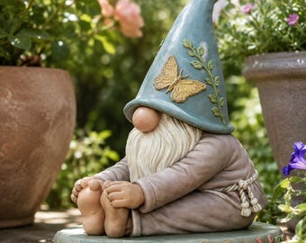 Peut inclure: Une figurine de nain de jardin assise sur une base circulaire ornée de fleurs et de papillons. Le nain porte un chapeau pointu bleu avec un papillon doré et une vigne en relief, une robe beige avec une ceinture en corde, une barbe blanche.