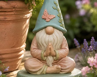 Peut inclure: Une figurine de nain de jardin en position assise du lotus, les mains jointes en signe de prière. Le nain porte un chapeau pointu bleu clair orné d'un papillon rose et de vignes, ainsi qu'une tunique pêche sur une base ronde verte.