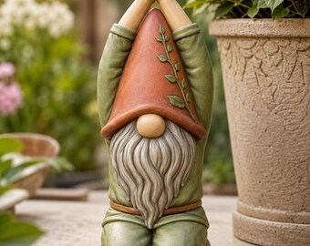 Peut inclure: Une figurine de nain de jardin en position agenouillée, les mains jointes au-dessus de la tête. Le nain porte un grand chapeau couleur terre cuite avec un motif de vigne, une tunique verte et une longue barbe grise sur un socle circulaire.