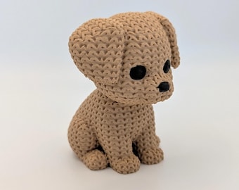 May include: A small, tan puppy figurine with a textured surface. The puppy is in a sitting position, with black eyes and a black nose. The ears are floppy, and the design is simple and charming.