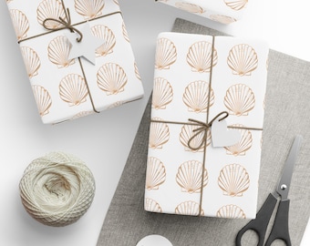 May include: Three white gift boxes with a brown seashell pattern. The boxes are tied with brown twine and have white gift tags attached. The boxes are on a light gray surface with a brown fabric background.