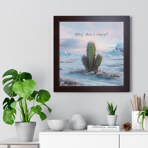 Puede incluir: Una impresión enmarcada de un cactus en un paisaje nevado con el texto "Why Am I Here?" impreso arriba.