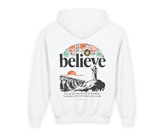 May include: White hoodie featuring the word "believe" in a bold, black font, arched above a graphic of a figure on a hill with a crowd below. The design includes floral accents in orange, green, and blue. The text "Do not let your hearts be troubled. You believe in God, believe also in me." is printed below.