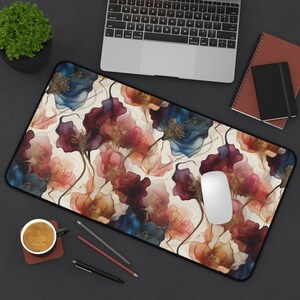 May include: A floral patterned mouse pad with a white background and a variety of colors including blue, red, pink, and gold. The mouse pad is rectangular and has a black border.