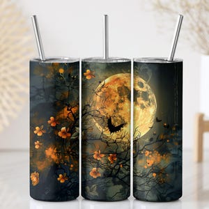 May include: Three stainless steel tumblers with a Halloween-themed design. The design features a full moon, bats, and a tree silhouette with orange flowers against a dark background. Each tumbler has a silver straw.