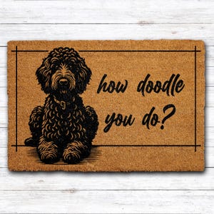 May include: A rectangular doormat with a black doodle dog illustration and the text "how doodle you do?" in a playful font. The mat is brown with a black border and is placed on a white wooden surface.