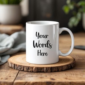 May include: A white ceramic mug with a handle on the right side. The front of the mug features the black printed text "Your Words Here" in a cursive script font. The mug is cylindrical with a smooth finish and a standard circular rim.