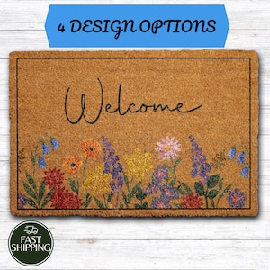 May include: A rectangular tan coir doormat featuring the word Welcome in black cursive script. The bottom section displays a colorful floral print with red, orange, yellow, blue, and purple flowers and green leaves. A blue banner at the top reads 4 DESIGN OPTIONS.