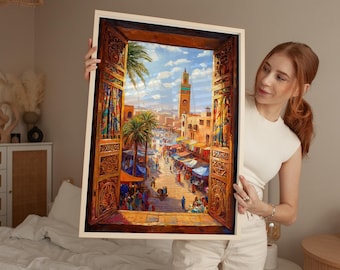 Può includere: Una stampa d'arte incorniciata che mostra una vista attraverso una porta in legno intagliato e decorato verso un vivace mercato marocchino. La scena presenta palme, bancarelle colorate e un alto minareto sotto un cielo azzurro.