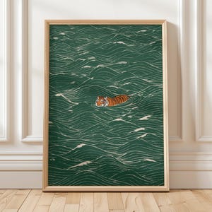 Pu&ograve; includere: Una stampa artistica incorniciata raffigura una tigre che nuota in un mare di onde verdi. La tigre ha strisce arancioni e nere. Le onde sono dettagliate con linee bianche, creando un effetto strutturato. La cornice &egrave; color legno chiaro.