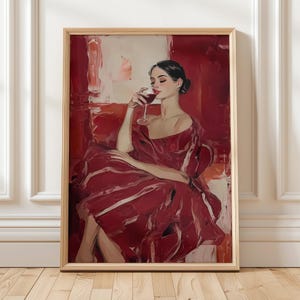 Op de afbeelding: Een ingelijste kunstdruk toont een vrouw in een rode jurk, zittend en rode wijn drinkend. Het kunstwerk gebruikt een rijk palet van rood en wit, waarbij de elegante pose van de vrouw en het wijnglas worden benadrukt. Schilderachtige stijl.
