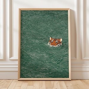 May include: A framed art print featuring a tiger's head emerging from green water with white wave patterns. The tiger has orange and black stripes with white accents. The frame is a light wood color.