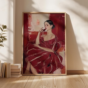 Op de afbeelding: Een ingelijste kunstdruk toont een vrouw in een rode jurk, zittend en wijn drinkend. Het kunstwerk gebruikt een gedurfd kleurenpalet van rood en wit, met een houten lijst. De vrouw is de centrale figuur in het schilderij.