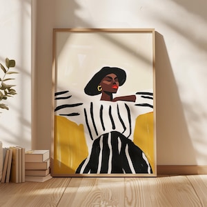 Op de afbeelding: Een ingelijste kunstdruk met een gestileerde illustratie van een persoon met een zwarte hoed, gouden oorbellen en een zwart-wit gestreept topje. Het kunstwerk heeft een geel en crème kleurenpalet, met een houten lijst.