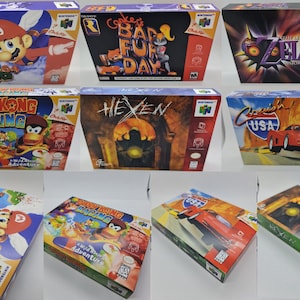 Könnte beinhalten: Eine Sammlung von Nintendo 64 Videospielboxen. Titel sind "Super Mario 64", "Conker's Bad Fur Day", "The Legend of Zelda: Majora's Mask", "Diddy Kong Racing", "Hexen" und "Crush USA". Die Boxen zeigen farbenfrohe Grafiken und Spieletitel.